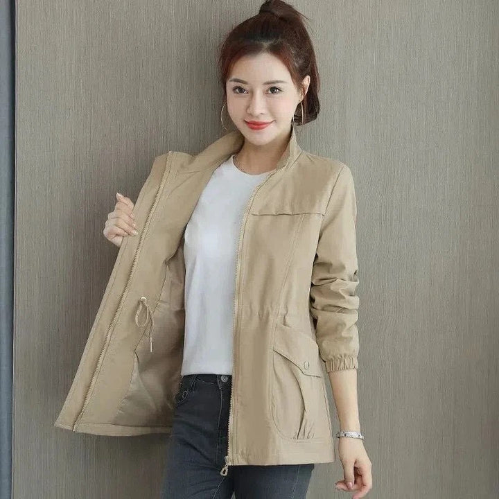 "Dames trenchcoat met verstelbare taille, voorzakken en opstaande kraag, elegante jas in lichte stof, ideaal voor lente."