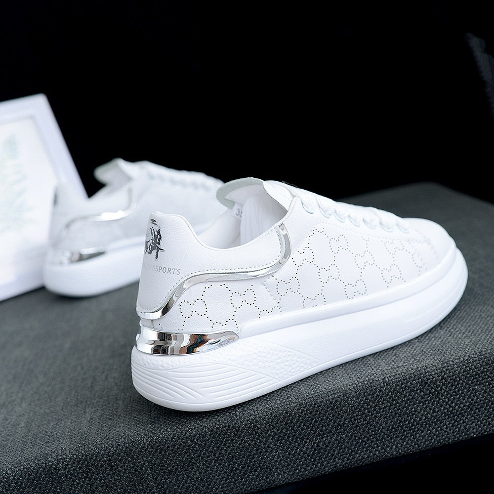 Close-up TrienkesSneaks, witte dames sneakers met glanzende zilveren en subtiele gouden details.
