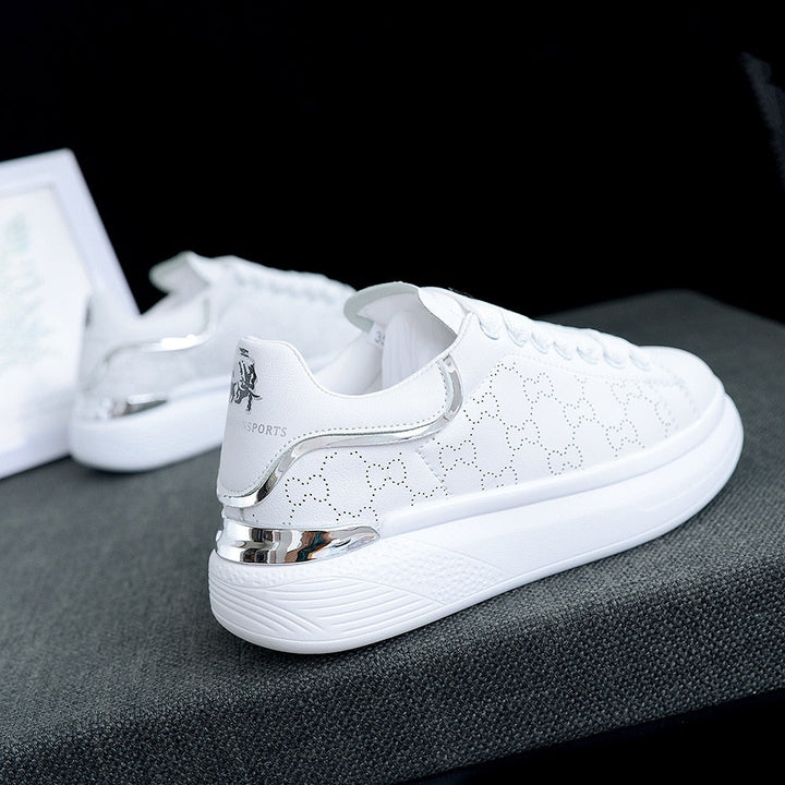 Close-up TrienkesSneaks, witte dames sneakers met glanzende zilveren en subtiele gouden details.