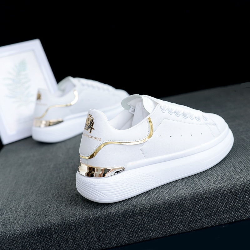 Zij-aanzicht van comfortabele TrienkesSneaks, modieuze witte en zilveren damesschoenen met gouden afwerking.