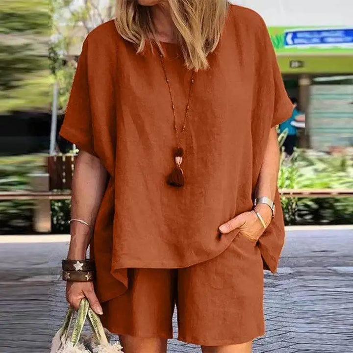 Vrouw draagt comfortabele tweedelige linnen zomerset met shorts en blouse, genietend van een zonnige vakantie.