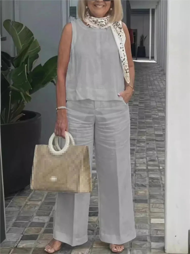 Veelzijdige dames zomerset met mouwloze linnen blouse en wijde broek; een stijlvolle outfit voor diverse gelegenheden.