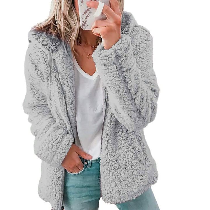 Vrouw draagt stijlvolle FluffyCoat™ damesjas met capuchon, een warme en comfortabele winteroutfit.