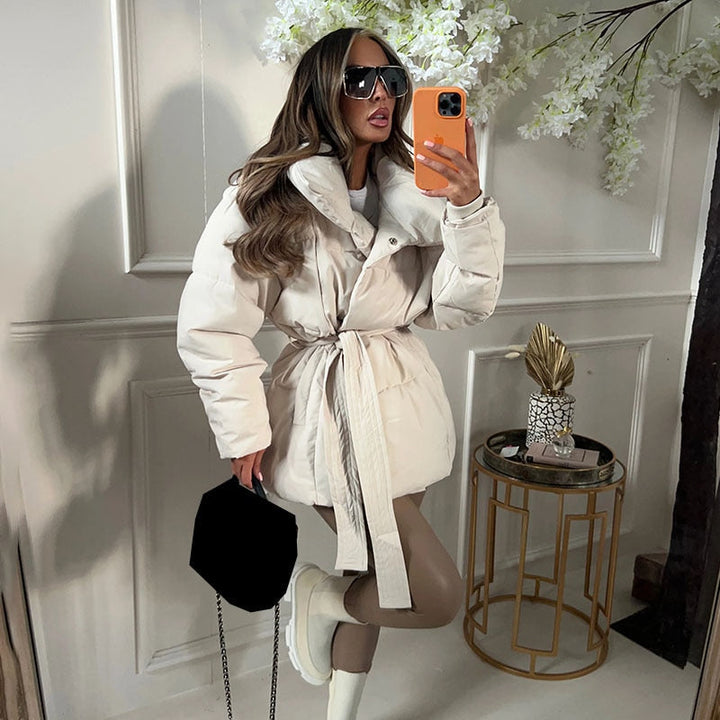 Dames warme winterjas met stijlvolle riem. Dikke, modieuze jas voor dames, perfect tegen de kou. Elegante bovenkleding.