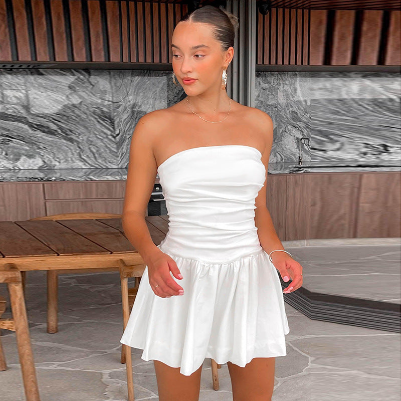 Model toont Nikki witte strapless mini-jurk met geplooide ruches, ideaal als elegante zomer- of feestjurk.