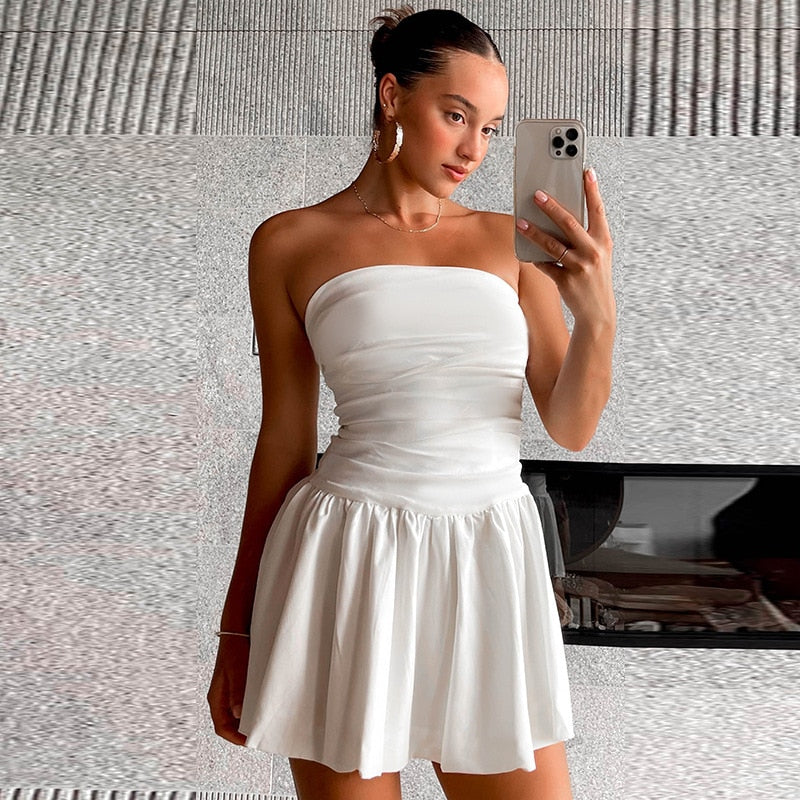 Trendy dames mini-jurk: wit, strapless en geplooid. Een chique keuze voor avondkleding of een zomerse gelegenheid.