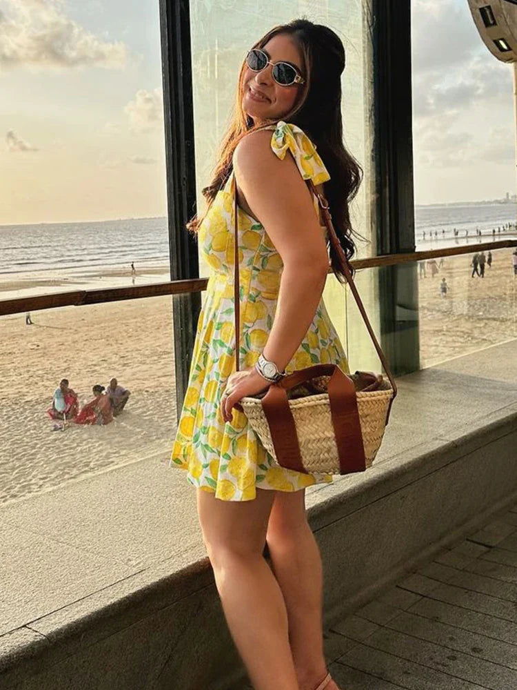 Model draagt een vrolijke Lianne dames zomerjurk met citroenprint, perfect voor een zomerse dag.