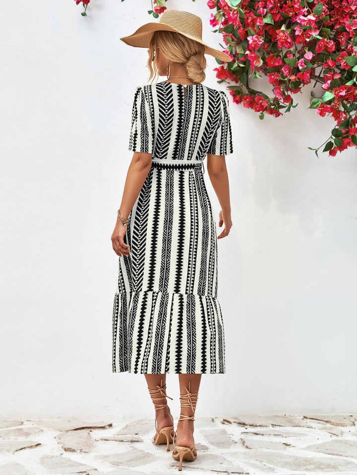 Stijlvolle dames jurk met zwart-wit strepen. Deze elegante midi-jurk met korte mouwen is ideaal voor elk seizoen.