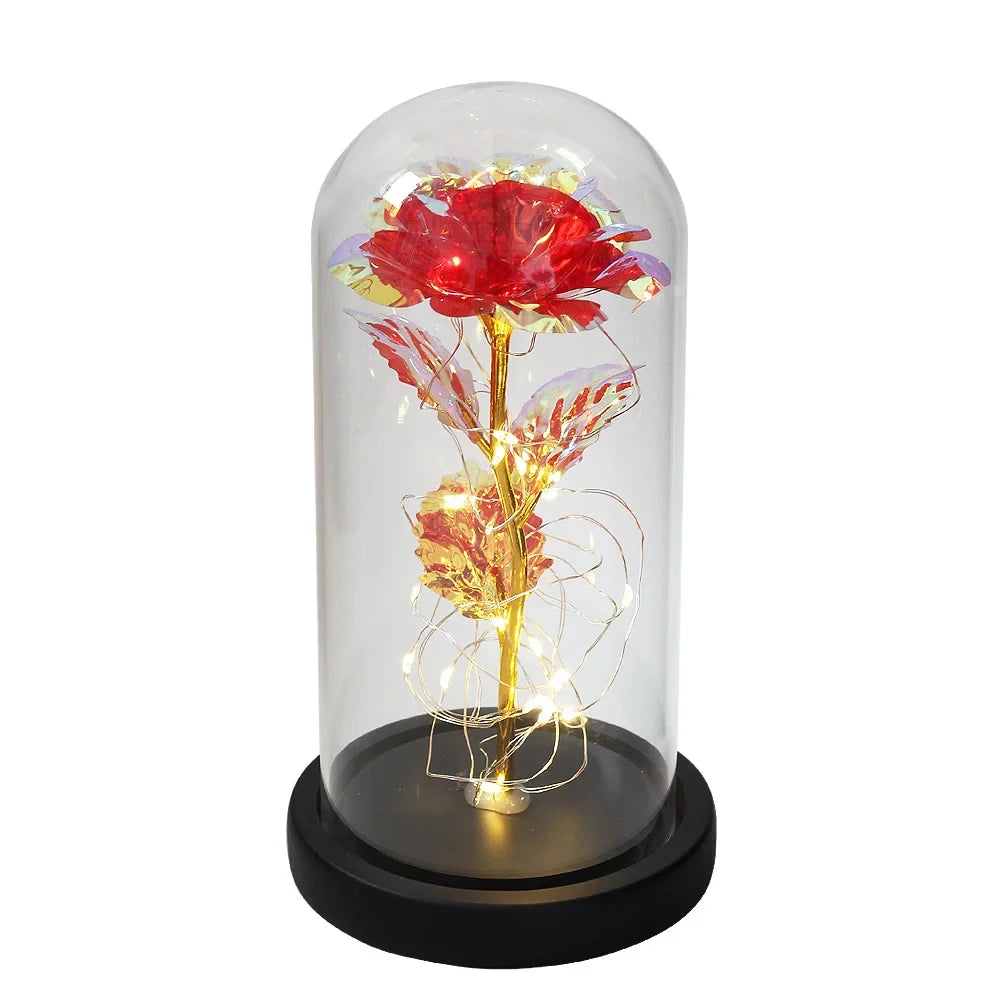 Decoratieve LED sfeerlamp met roos in glazen stolp, geeft warm wit licht.