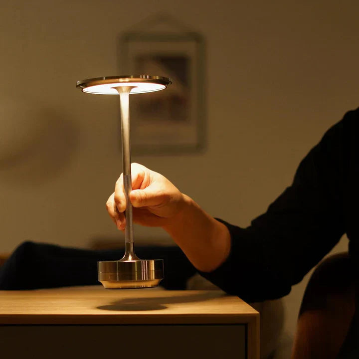 Oplaadbare draadloze LED lamp, dimbaar, creëert warm en sfeervol licht op tafel.