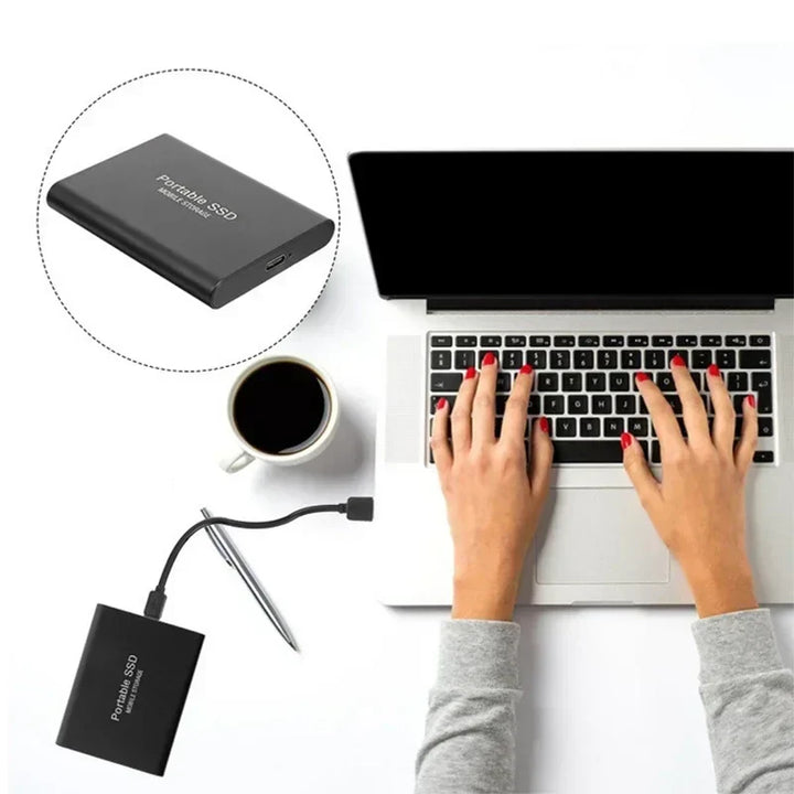 Compacte 2TB externe SSD naast smartphone, ideaal voor mobiele opslag en snelle data onderweg.