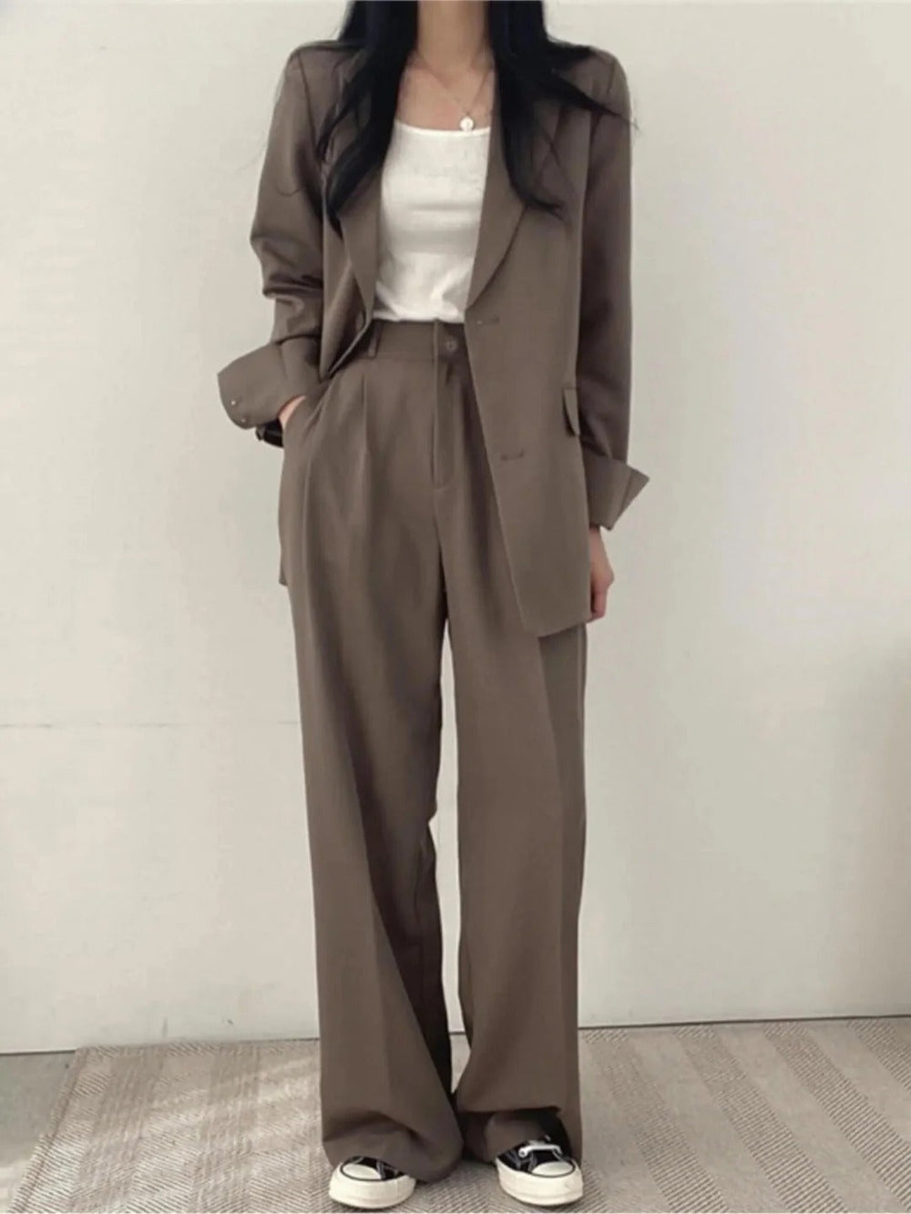 Comfortabel en veelzijdig damespak, bestaande uit een modieuze blazer en bijpassende pantalon. Perfect voor werk en vrije tijd.