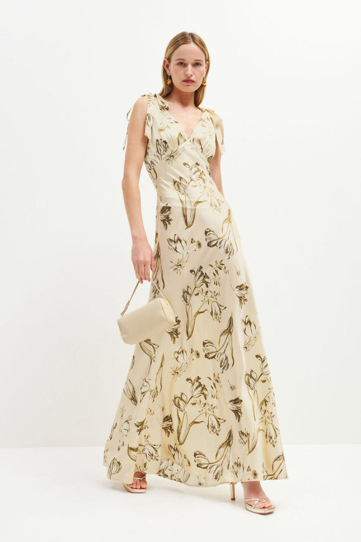 Elegante beige dames maxi-jurk met uitlopende pasvorm en knoopdetail; perfect voor zomer en vakantie.