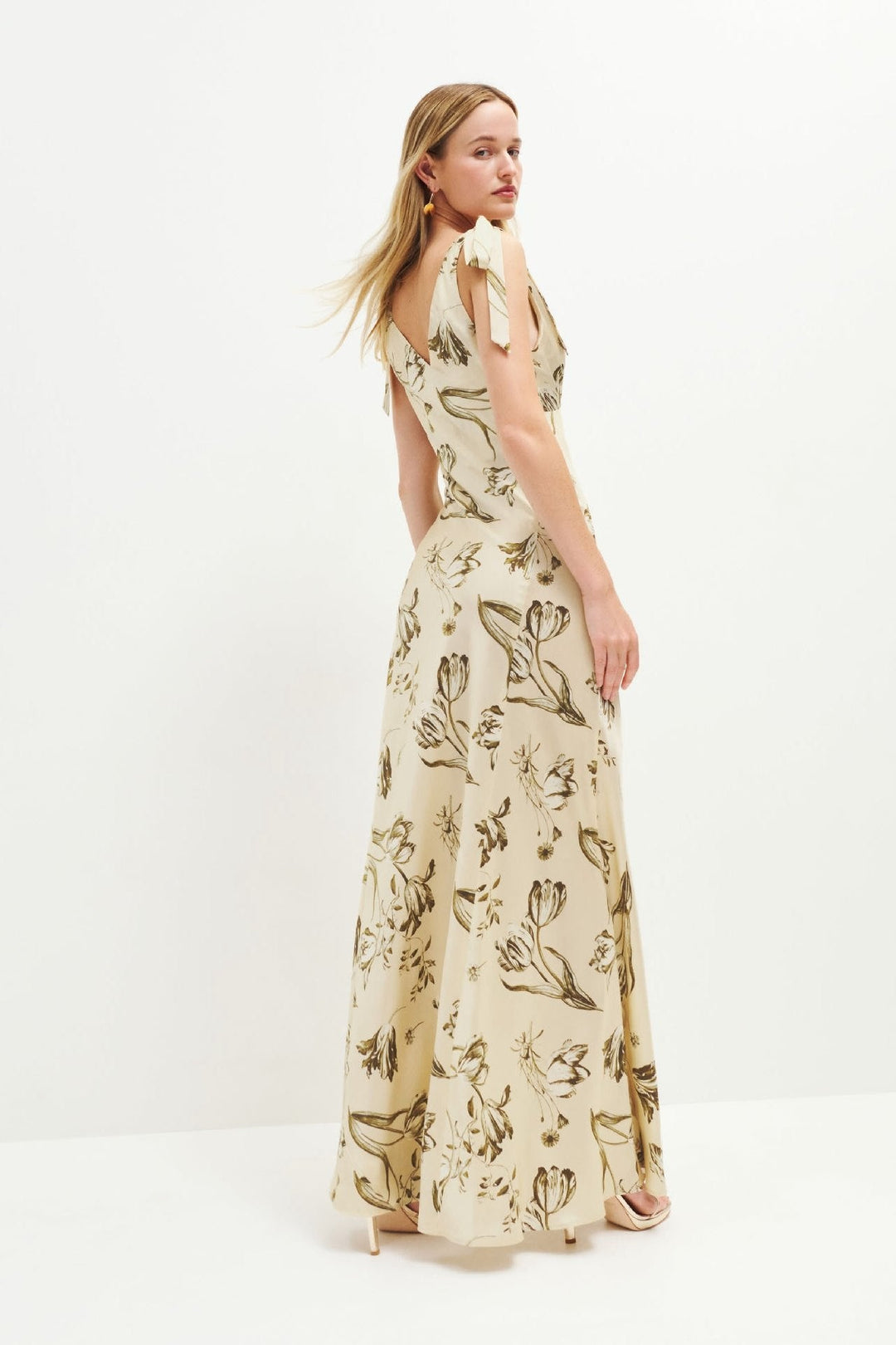 Stijlvolle beige uitlopende maxi-jurk voor dames met uniek knoopdetail. Een comfortabele en elegante zomerjurk.