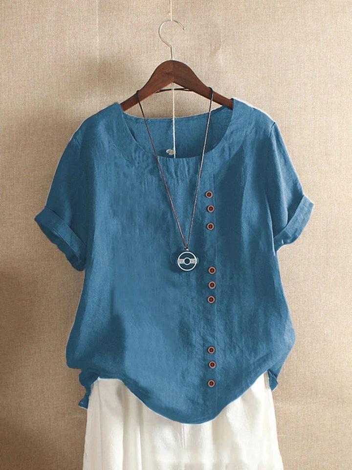 Luchtige dames blouse met korte mouwen, knoopdetails en peter pan kraag; perfect voor warme dagen.