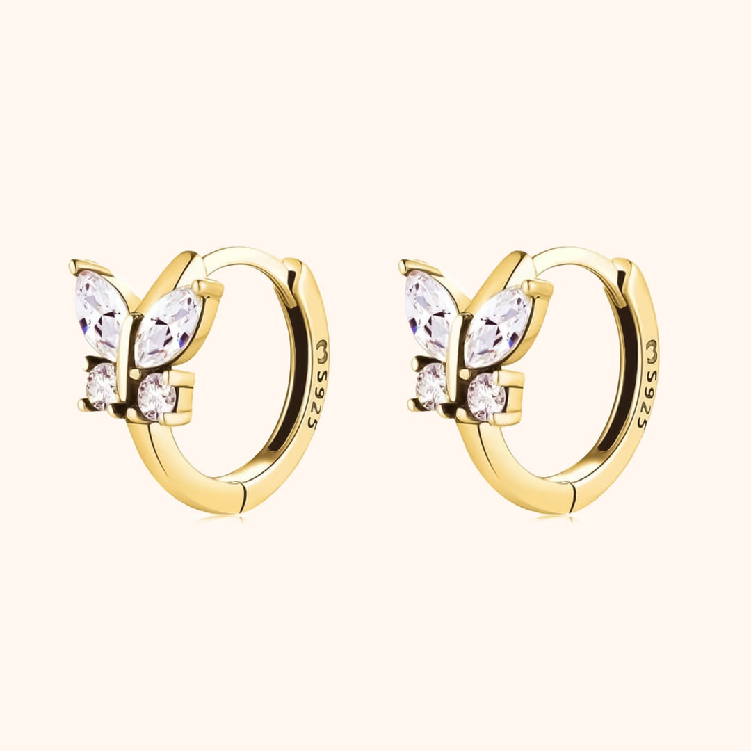 Glinsterende kristal vlinder oorbellen voor dames. Auryn creolen met elegante zilveren of gouden afwerking.