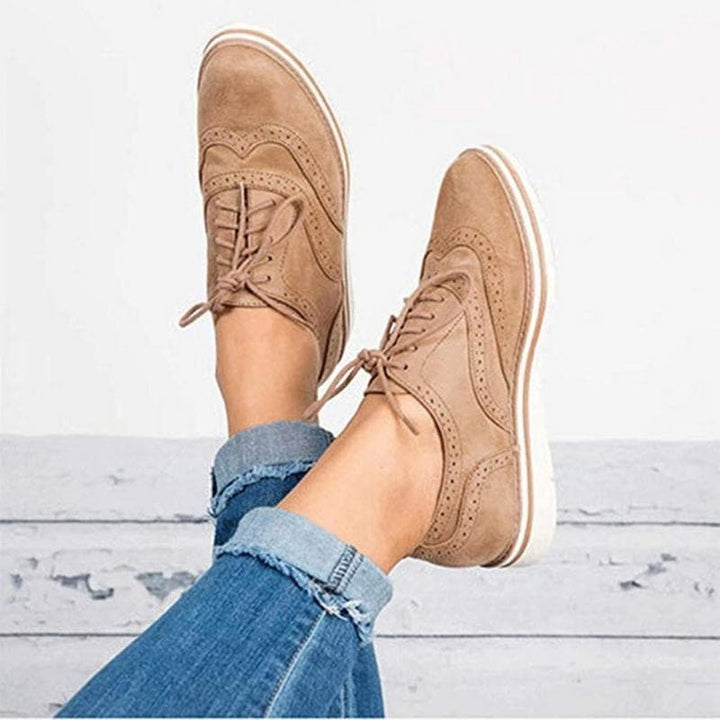 Dames derby schoen Carisse, taupe wildleder met verfijnde brogue perforaties en vetersluiting voor stijl.