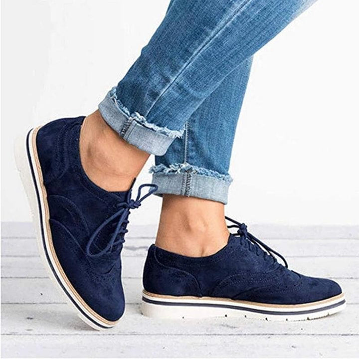 Close-up van de brogue details op de Carisse dames derby schoenen van zacht wildleder. Elegante veterschoenen.
