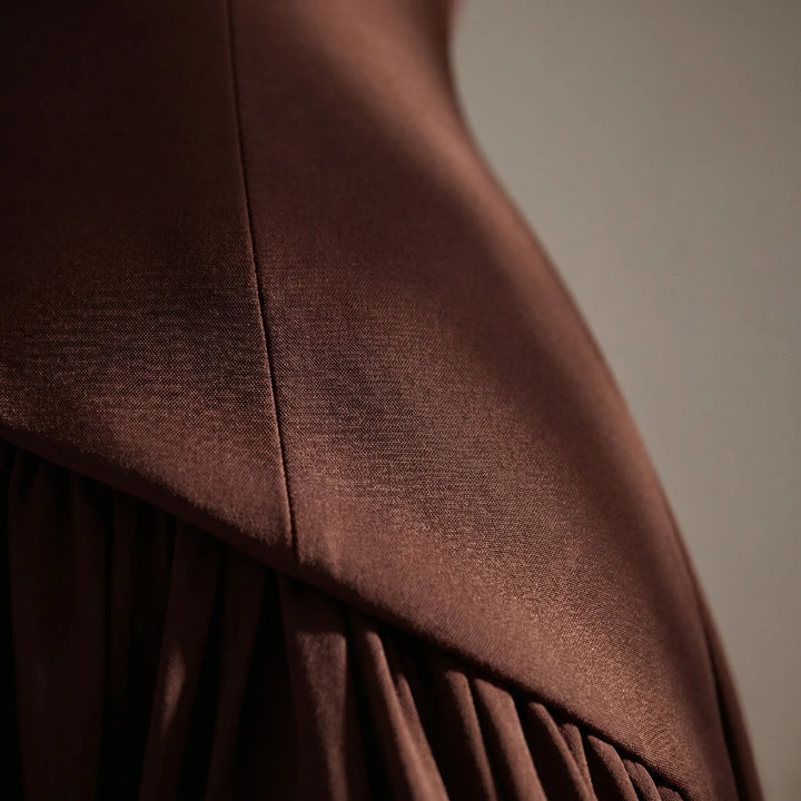 Formele damesjurk met uniek gestructureerd corset en elegant sjaaldetail, perfect als gala of statement jurk.
