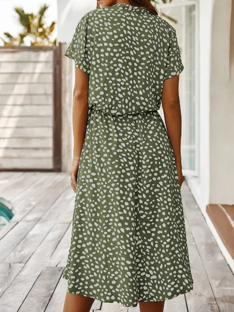 Detailopname van de bloemige print op een elegante dames zomerjurk, benadrukt de stof en kleuren.