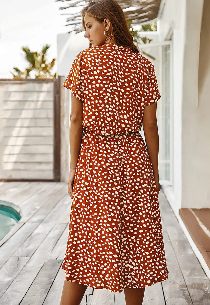 Model draagt een comfortabele dames midi jurk met bloemenprint, perfect voor een zomerse dag.
