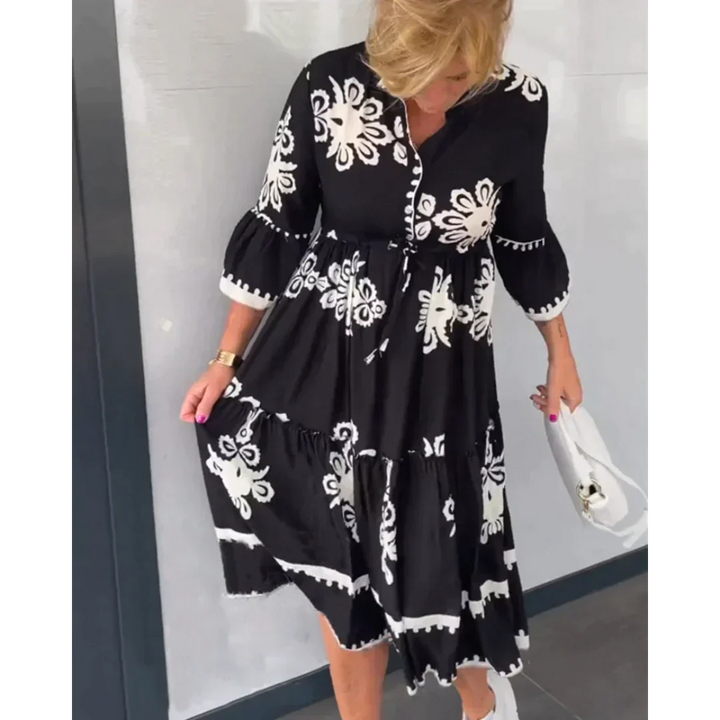 Vrolijke dames zomerjurk met bloemenprint en 3/4 mouwen, stijlvol gedragen voor een lente- of zomerse dag.