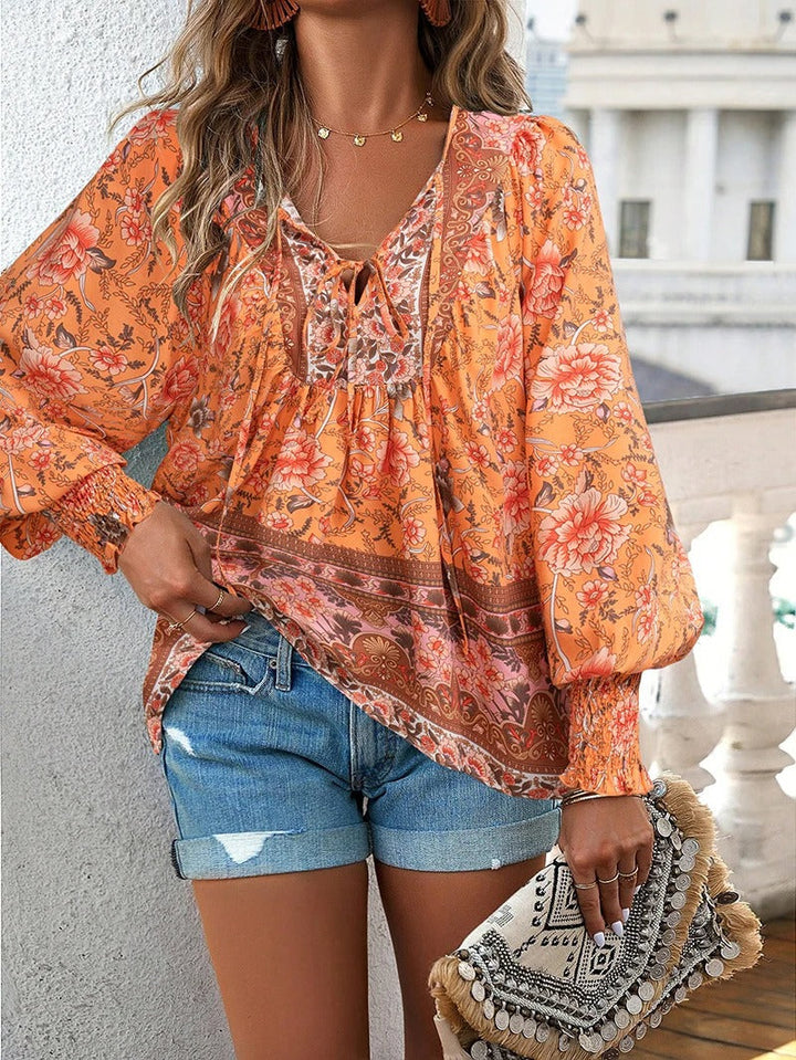 Soepelvallende damesblouse met bloemenprint en lange mouwen. Elegante top voor feestelijke gelegenheden.