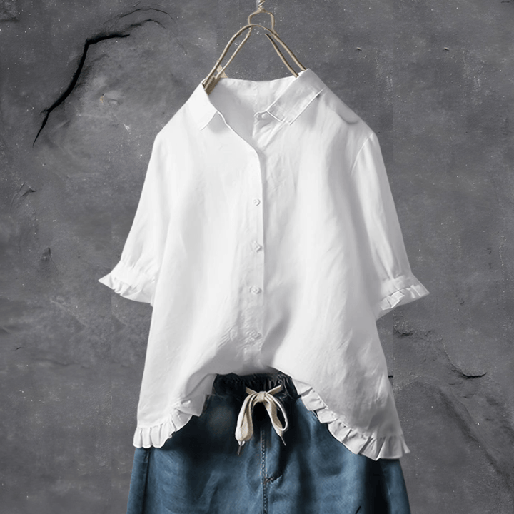 Casual zomerblouse met losse pasvorm en ruchezoom. Comfortabele damesblouse met knopen en driekwart mouwen.