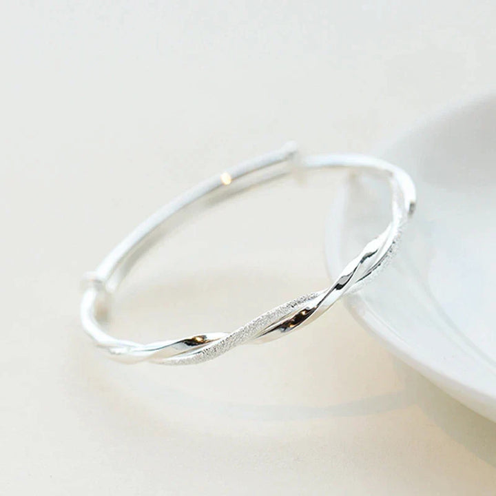 Gedraaide dames armband elegant gedragen om een pols, een verstelbaar en stijlvol accessoire. Perfect cadeau.