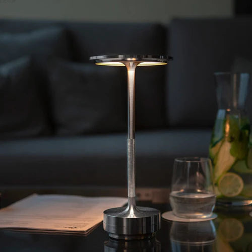 Draadloze LED tafellamp NordicaLight creëert warme sfeerverlichting in een modern woonkamerinterieur.