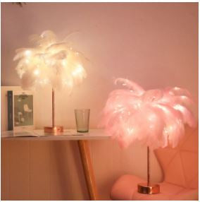Sfeervolle Feather Lamp™️ op nachtkastje. Creëert romantische slaapkamerverlichting.