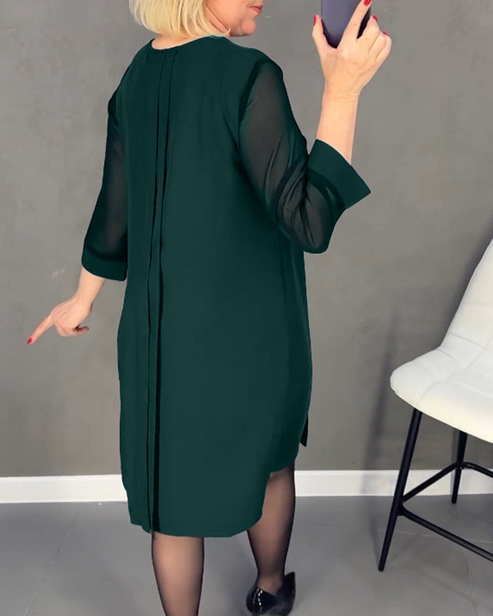 Zwarte dames shiftjurk met chique meshdetails. Lange mouwen en knielang, combineert elegantie met comfort.