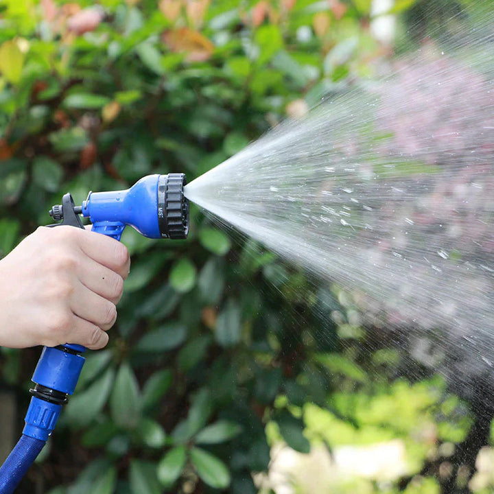 Persoon besproeit planten met flexibele FlexaFlow tuinslang; perfect voor watergeven in de tuin.
