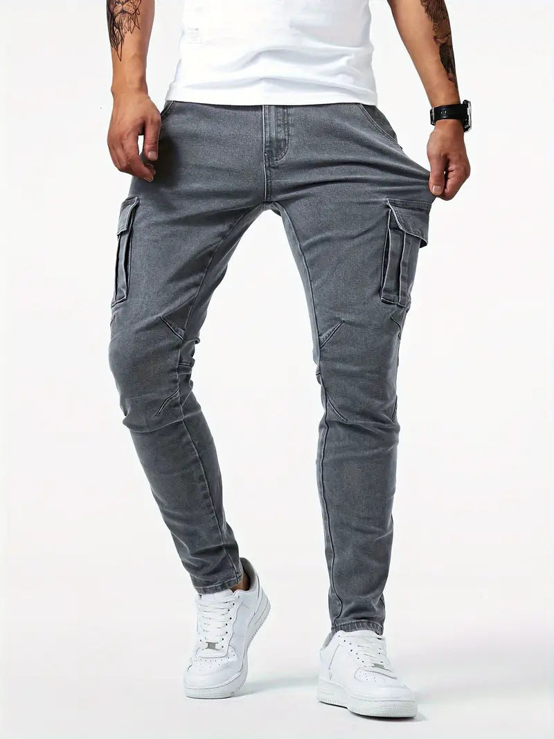 Man in grijze slim fit cargo jeans toont stretch bij de tailleband, met focus op comfort.
