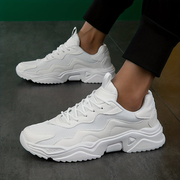 Witte ademende heren sneakers gedragen op een donkere ondergrond