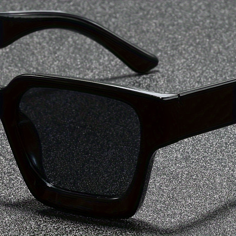 Detailopname van het glanzende zwarte montuur en de donkere lens van de retro zonnebril.