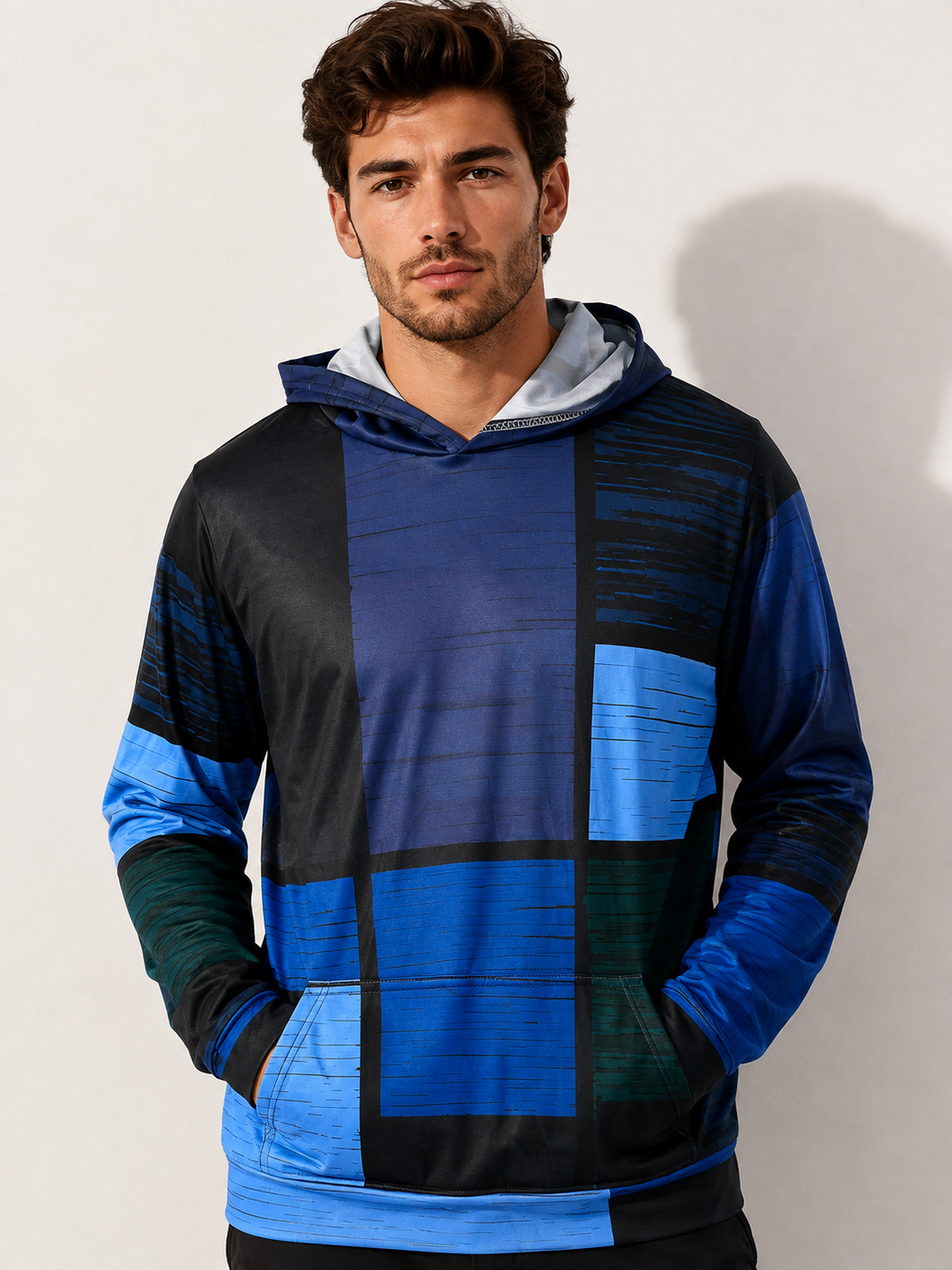 Stijlvolle heren hoodie met blauwe en zwarte 3D ruitprint gedragen door een man, frontaal.