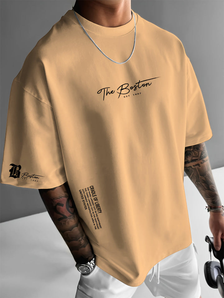 Close-up van trendy slogan print op comfortabel heren T-shirt, ideaal voor casual zomerlooks en streetwear.