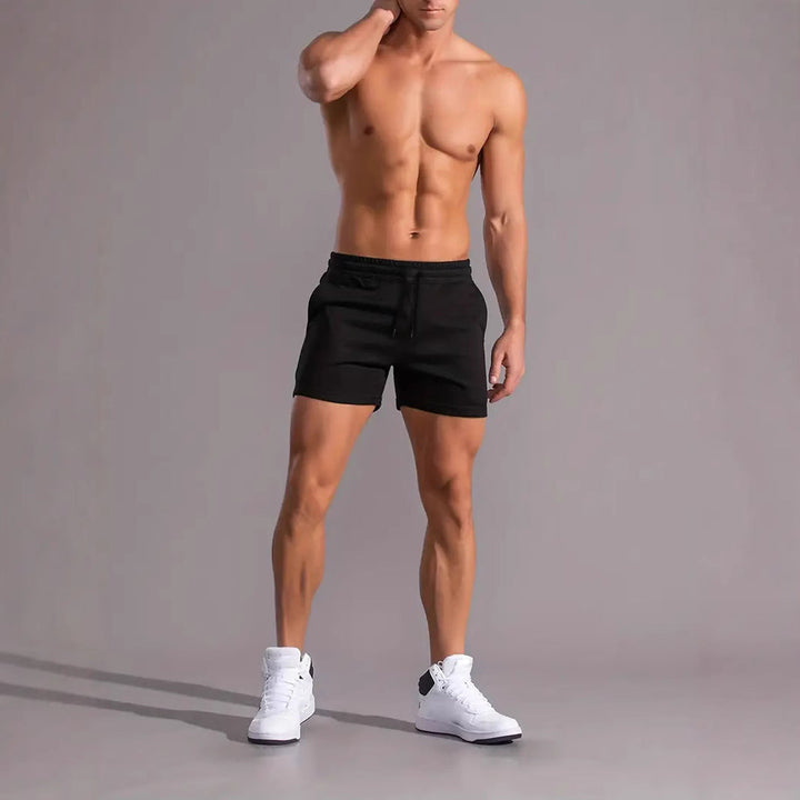 Man draagt zwarte sportshort voor heren tijdens fitness
