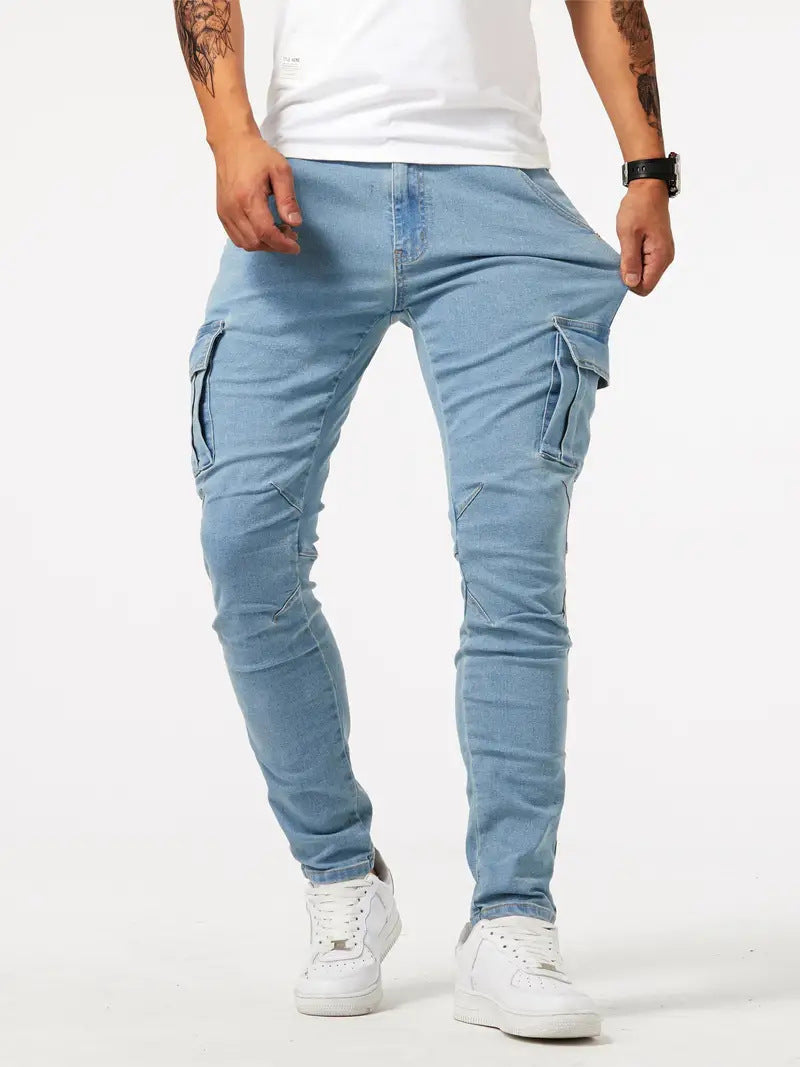 Man met lichte blauwe slim fit cargo jeans en witte sneakers op een witte achtergrond.