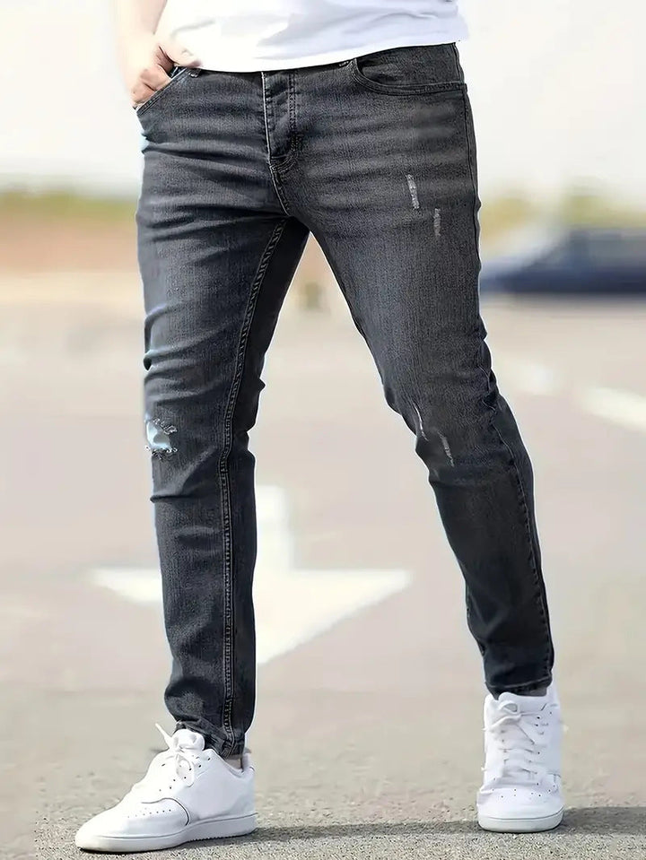 Man draagt donker-grijze skinny heren spijkerbroek met casual look