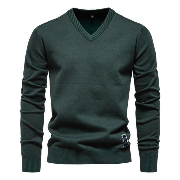 Man draagt een donkergroene klassieke V-hals trui in een elegante casual stijl.