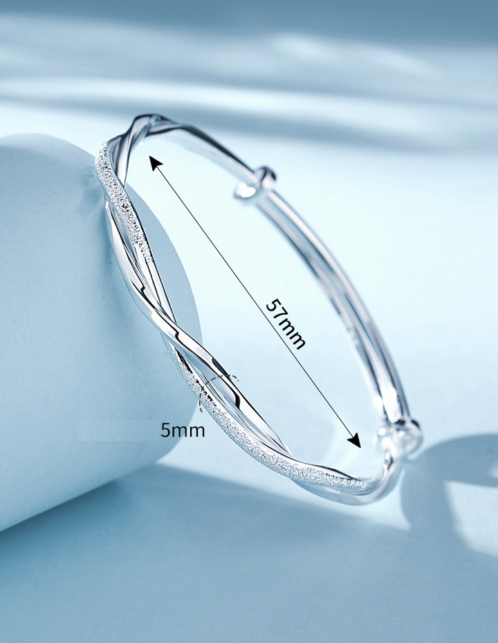 Damesarmband van gedraaid zilver, een modieus en veelzijdig sieraad.