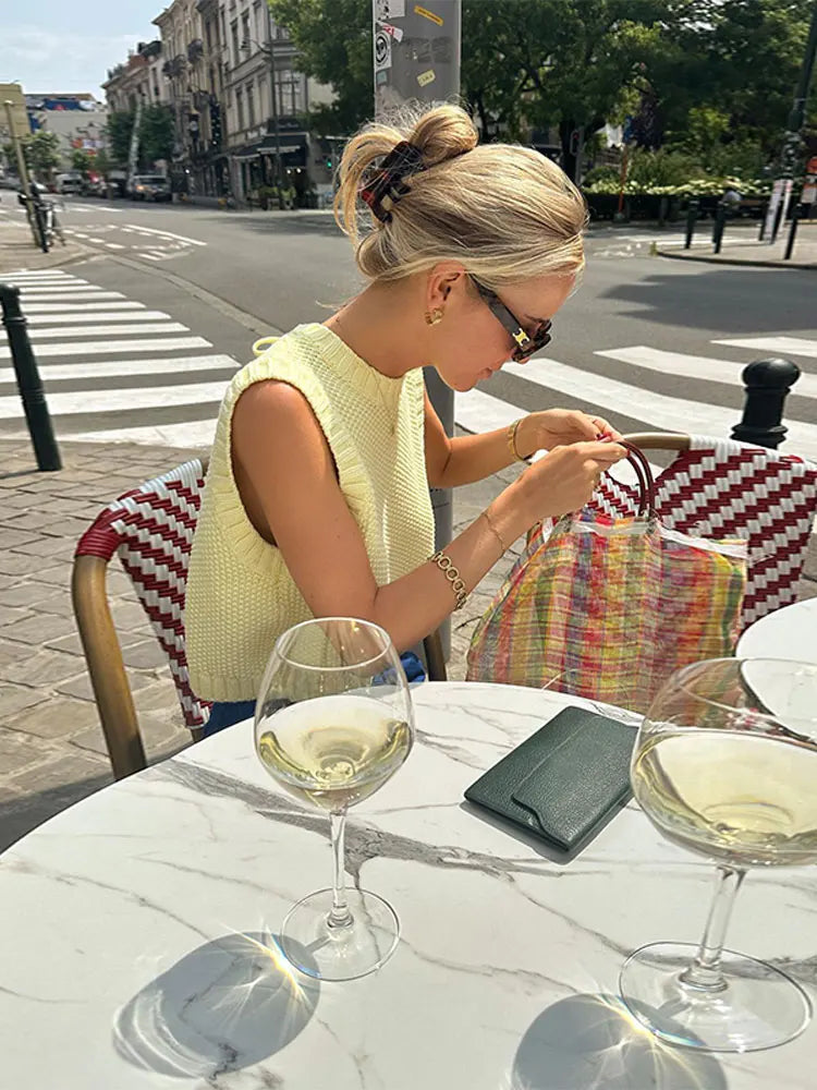 Comfortabele gele mouwloze dames top met luchtige breistructuur, ideaal voor warme zomerdagen.