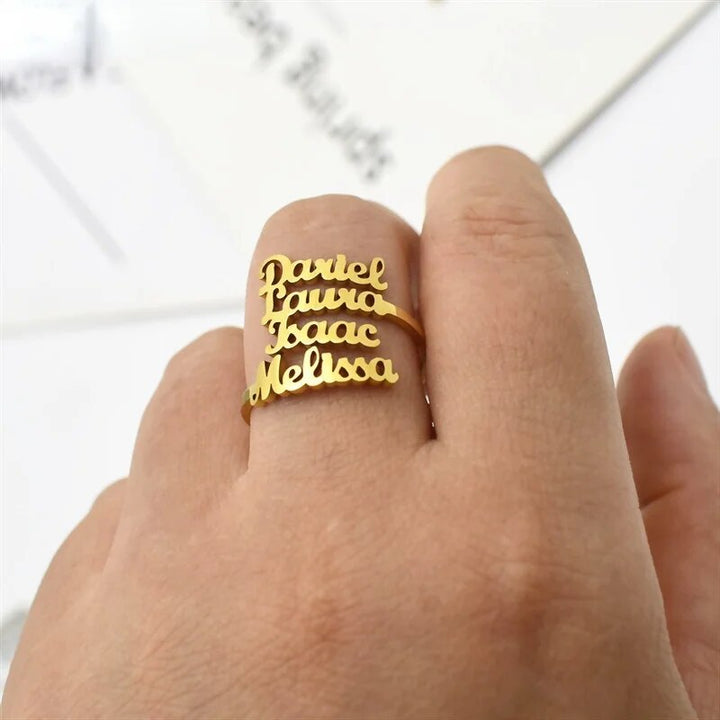 Detail van een hand met een gepersonaliseerde naamring van roestvrij staal. Stijlvol unisex sieraad.