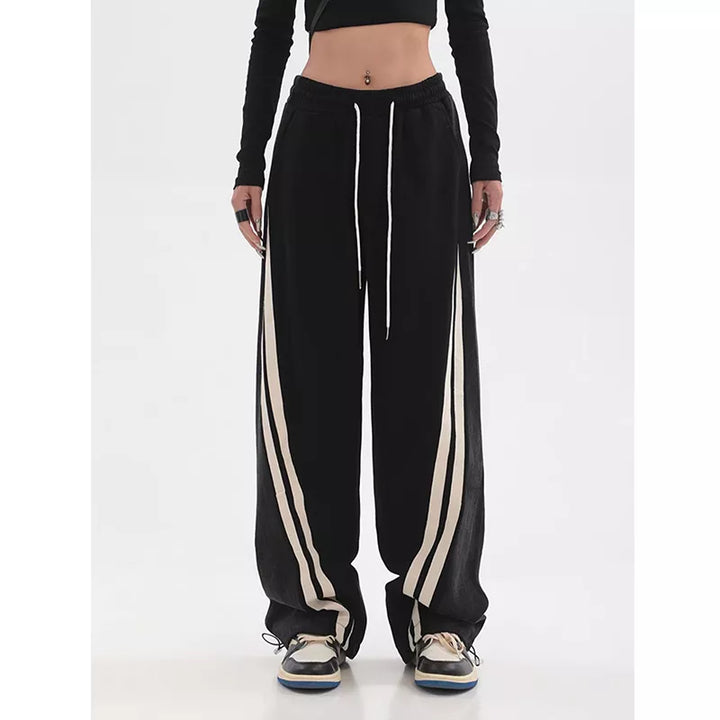 Sportieve dame draagt zwarte joggingbroek met hoge taille tijdens workout. Activewear mode.