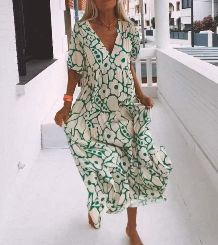 Zomerse groene maxi jurk met levendige print en korte mouwen. Comfortabel, A-lijn model met V-hals voor dames.