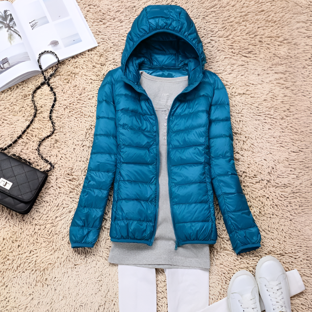 Stijlvolle blauwe dames donsjas, warm en ultralicht, opvouwbaar met capuchon, perfect voor winterreizen.