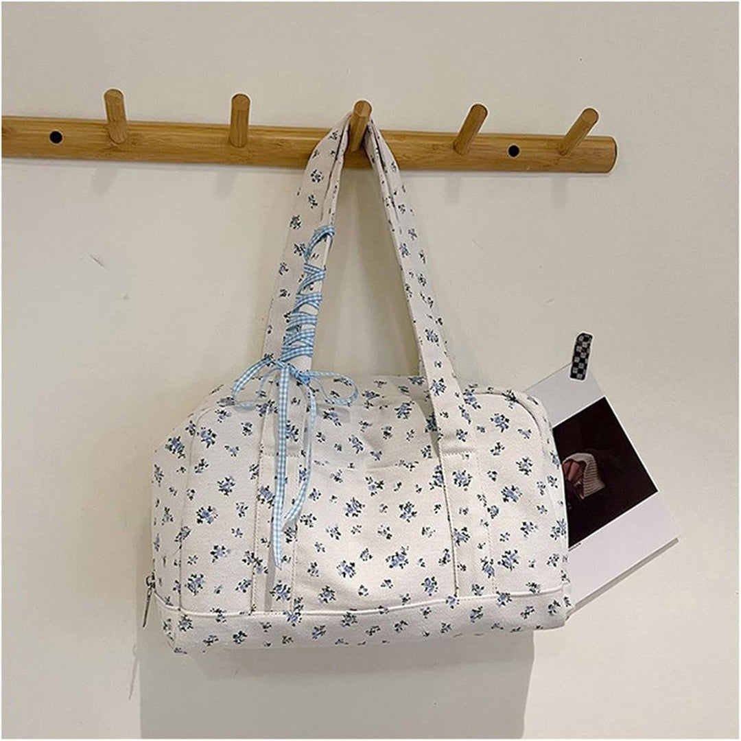 Grote canvas dames weekendtas met lintaccent, gedragen om de functionaliteit te tonen.