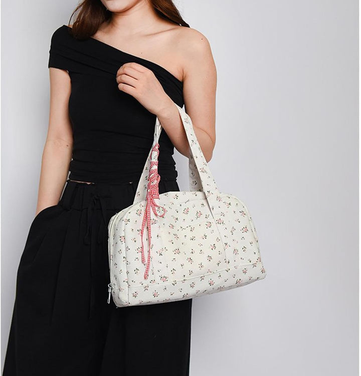 Roze canvas duffeltas voor dames, met modieus lint, ideaal als stijlvolle reistas of handbagage.